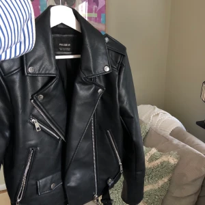 Svart skinnjacka - Svart skinnjacka från Pull&Bear! Endast använd ett fåtal gånger, jackan är i strålande skick😍 Den är rejäl/tjock i tyget vilket gör att den sitter väldigt snyggt på och ser ej billig ut! Ganska liten i storlek. Hör av dig ifall du vill ha fler bilder💓