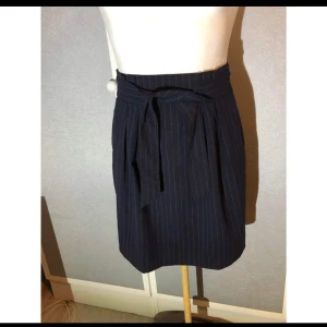 Kjol från HM - Så gott som ny. Knytdetalj fram och med dragkedja bak.