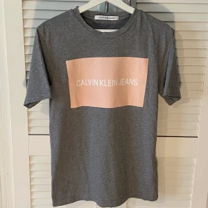  Calvin Klein - Grå T-shirt - Använd några gånger men är fortfarande som ny! Säljer ändast då den inte kommer till användning längre