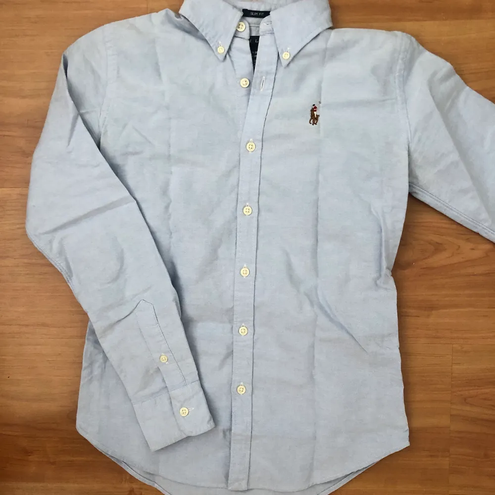 Säljer den här fina Ralph Lauren skjortan som är i nyskick. Den är ljusblå och är i storlek 0 (slim fit) vilket motsvarar XS. . Skjortor.
