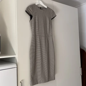 Grå H&M kostymklänning strl 34/XS - Fin grå lite ”preppy” klänning från H&M. Väldigt bra skick, nästintill oanvänd. Formar sig jättefint efter kroppen men tyvärr för liten för mig därav vill jag sälja den.