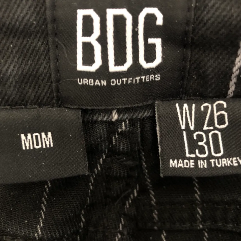 Mom jeans från Urban Outfitters märke BDG. Svarta jeans med vita ränder. Sitter jättefint. Använda några gånger men fortfarande mycket bra skick. Storlek W26 L30 passar S-M. Pris inklusive frakt.  . Jeans & Byxor.