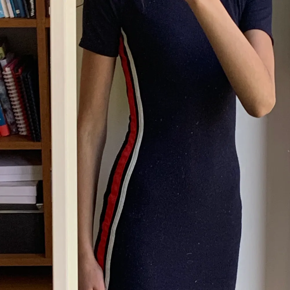 Marinblå klänning med vita och röda linjer på sidorna. Den är ganska nopprig så det är därför den säljs så billigt😇. Klänningar.