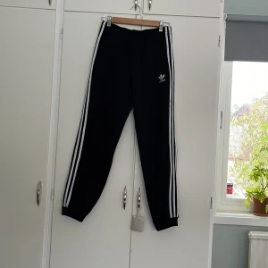 Träningsoverallbyxor - Små märken på vita stripes på ena sidan