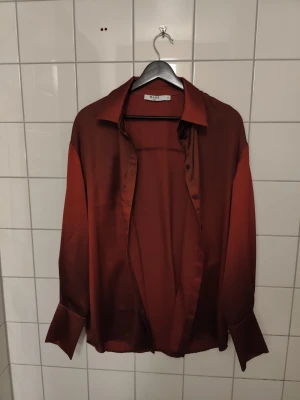 Skjorta  - Röd/vinröd satinskjorta från NA-KD. Jag brukar ha s-m, sitter oversize på mig 
