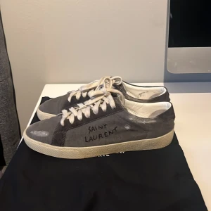 Saint Laurent sneaker - Saint Laurent skor i storlek 40 men passar definitivt större, cirka 42. Slitningarna på skorna är eb del av modellen. Kommer med original påse till skorna. Skorna är använda varsamt och väl omhändertagna. 