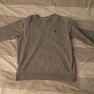 Grå Polo Ralph Lauren sweatshirt - En grå polo tröja. Storlek M passar bra mellan längden 170-180. (Det var så lång jag va när jag använde den) Bra skick. Pris diskuteras