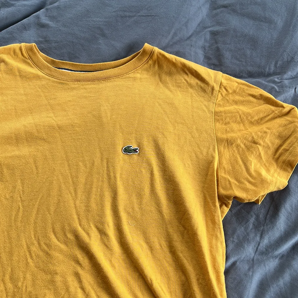 Säljer denna gula och fina t-shirt från Lacoste i stolek 164/XS. T-shirts.