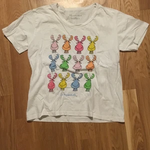 Vit t-shirt med älgar - En jättegullig vit t-shirt med älgar på. Passar storlek XS-S skulle jag säga. Är i väldigt bra skick. Frakt ingår ej 
