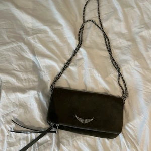 Zadig Voltaire väska - Säljer den här fina Zadig väskan som tyvärr inte kommer till användning längre. Den är en fin mörkgrön färg som syns bättre på bild 2. Den är sparsamt använd så i väldigt fint skick. Köpte den ny för ca 3200 kr. 