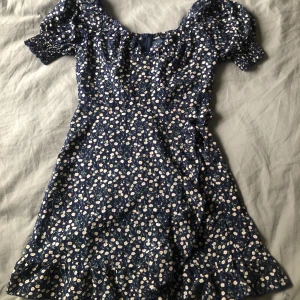 Klänning  - Fin mörkblå klänning med blommor på