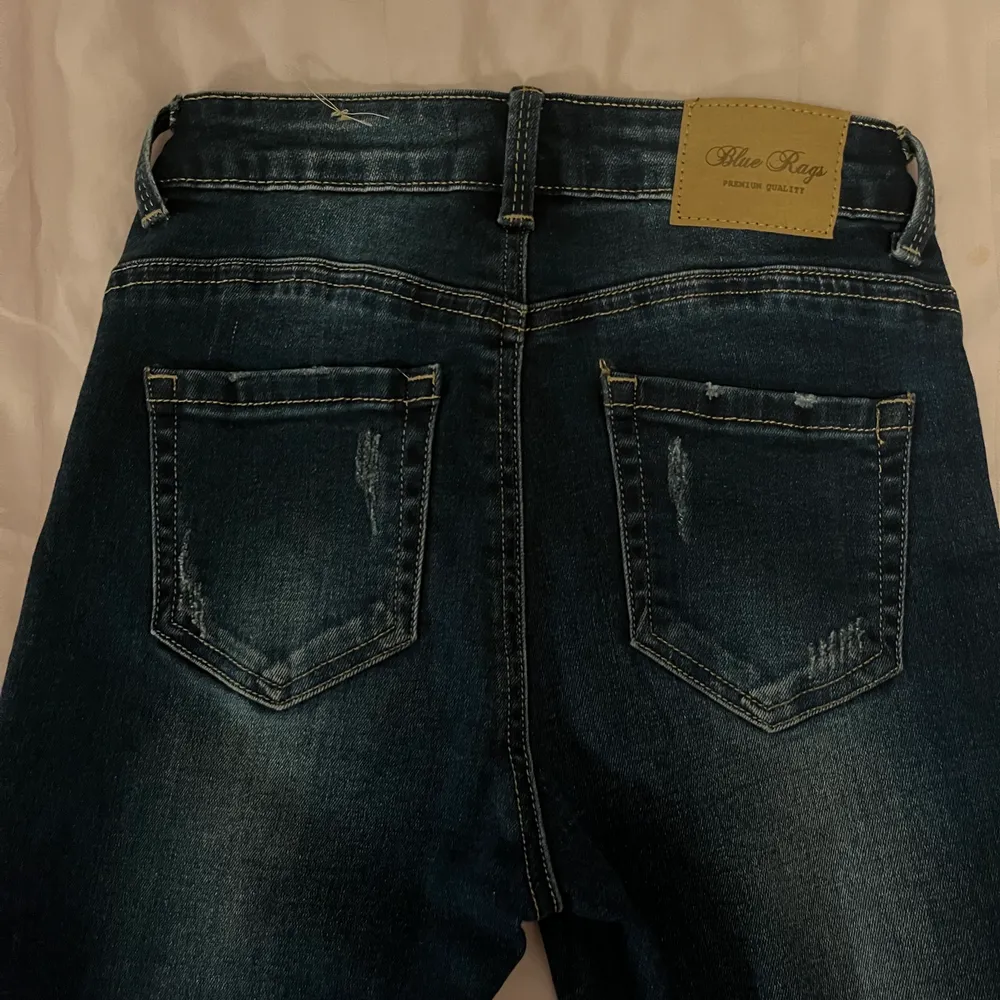 Blåa jeans med ett rött streck på sidan av benet. Storlek 36 enligt lapp men skulle säga att de är som 34. Från märket Blue rags. Använda ett par gånger. . Jeans & Byxor.