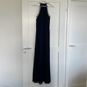 ZARA långklänning strl M - ZARA maxiklänning strl M, använd en gång som ny. Snören vid halsen och midjan som man kan justera själv. Marinblå med pärlor som detalj