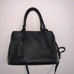 Black ochnik bag with dark green and white details. Excellent condition, comes with a removable and adjustable cross body strap. The bag itself has 2 compartments, an open outer area that wraps to both sides and a middle area that zips up