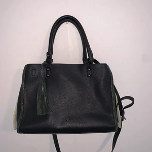 Large black purse - Black ochnik bag with dark green and white details. Excellent condition, comes with a removable and adjustable cross body strap. The bag itself has 2 compartments, an open outer area that wraps to both sides and a middle area that zips up