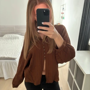 Blus från zara - Säljer en brun flowy blus med långa ärmar och flera knappar framtill. Linne/bomullstyg.