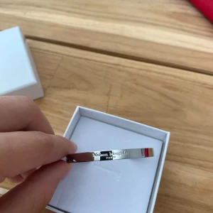 Maison Margiela silverarmband - Stilrent armband från Maison Margiela i 925 silver, tillverkat i Italien. Armbandet har en minimalistisk och modern design med Maison Margiela-loggan ingraverad på framsidan. Kommer i original ask. Cuff Bracelet.