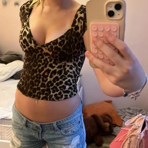 Leopardmönstrad topp från SHEIN - Säljer en snygg leopardmönstrad topp från SHEIN i storlek S. Toppen har v-ringning, korta ärmar och figurnära passform. Materialet är mjukt och stretchigt, perfekt för att sticka ut med ett djurmönster. Passar dig som gillar trendiga stilar. ❤️❤️