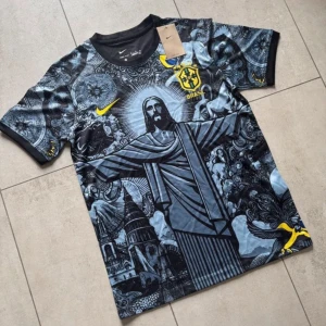 Nike Brasil Dri-Fit fotbollströja M - Unik Brasilien fotbollströja från Nike med svart och grått konstnärligt mönster, stora tryck av Kristusstatyn och detaljer i gult. Tillverkad i Dri-Fit material som andas. Korta ärmar och rund hals. Perfekt för dig som vill sticka ut på planen.