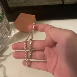 Flätat silverarmband - Snyggt armband i silverfärg med flätad kedja och klassiskt lås. Perfekt accessoar för att lyfta din stil och funkar lika bra till streetwear som till mer dressade outfits.