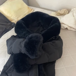 Svart pufferjacka med fuskpäls Copperose - Säljer en svart pufferjacka från  i storlek M. Jackan har en stor, fluffig krage och detaljer i fuskpäls som ger en lyxig vibe. Perfekt för kalla dagar när du vill hålla dig varm och ändå se snygg ut. Passar även non som vill ha storlek L har använt lite gran bara så den är nästan ny skick 💕köpte den för 2300 kr men säljer för 1500 / priset kan diskuteras 