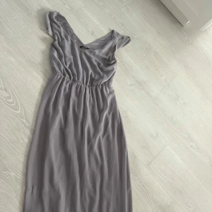 Ljusgrå långklänning från Bik Bok - Supersnygg ljusgrå långklänning från Bik Bok med v-ringning och resår i midjan.Knappt använd då jag ej har haft användning för den tyvärr 🌸