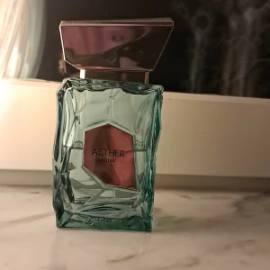 Aether Extrait parfymflaska -    Aether Extrait                                                                        Fräsch och livlig doft med inslag av citrus och gröna äpplen. Drygt 50 ml kvar. En unik, exklusiv parfym som ger en klar och energisk känsla. Perfekt för dig som vill sticka ut med något annorlunda! Originelt inspirerad av parfums de marly greenly men själv så föredrar jag den här. Den har e skurpturel form som inget jag sett förut en fantastisk och livlig parfym.                         Fråga gärna frågor😄