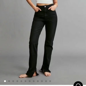 Svartgråa high waist slit jeans från ginatricot  - Säljer ett par svartgråa slim jeans med hög midja från gina i storlek 32. Jeansen har raka ben med slits och råa kanter nertill. 