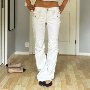 Vita low waist bootcut jeans - Vita byxor från Squeeze som är low waist med bootcut. Assballa och själv gillar jag att vika ner (tredje bilden) för ännu mer low waist look. Aldrig använt men köpt second hand, dock i fantastiskt skick. Säljer pga förstora. Hör av er vid frågor💕