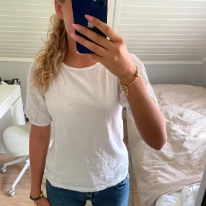 Vit blus med broderade ärmar - Säljer en söt vit blus med korta, broderade ärmar.