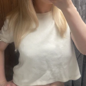 Vit kortärmad topp med pärldetaljer - Supersöt vit topp med korta ärmar och glittriga pärldetaljer längs ärmsluten från Zara