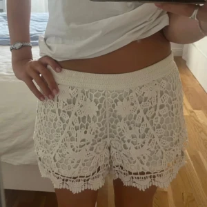 Vita virkade shorts med spetsdetaljer - Superfina vita shorts med virkad spets och blommiga detaljer. Perfekta till sommaren! Cremevita i färgen. 