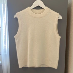 Cremevit stickad väst från Arket - En stilren cremevit stickad väst från Arket. Endast använd en gång, så i nyskick. Nypris 700 kr.