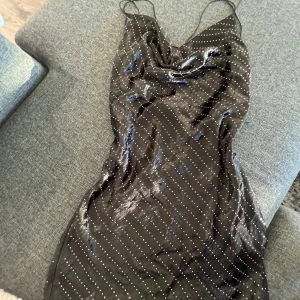 Svart glittrig klänning med öppen rygg - Supersnygg svart klänning med tunna axelband och öppen rygg. Från Zara perfekt för fest