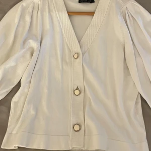 Vit kofta - Snygg vit kofta från Stockh LM. Koftan har trekvartsärmar med ribbade muddar. Perfekt om man vill ha en simpel kofta som passar till allt. Storleken är L men sitter perfekt på mig som har xs i vanliga fall. Då får man en mer oversized look.
