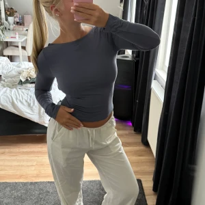 Rygglös topp från Gina - Grå blå topp från Gina med öppen rygg. Jag har sytt dit en egen knapp så att toppen hålls på plats och ej halkar av axlarna, fungerar toppen och blev så bra lösning på att rygglösa toppar ramlar av. 