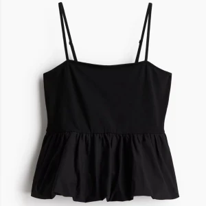 Svart volangtop med smala axelband - Supersnygg svart topp med smala justerbara axelband och volang nertill. Modellen är ärmlös och har en luftig, lätt utsvängd passform som ger en cool siluett. Perfekt att styla med jeans eller kjol för en trendig look. Storlek XXS passar även XS från HM och helt slutsåld. Skriv för frågor eller fler bilder.