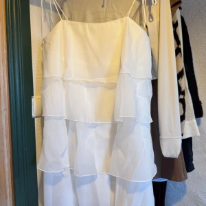 Vit organza volangklänning från Gina Tricot - Superfin oanvänd vit kort klänning i organza från Gina Tricot. Klänningen har tunna axelband och flera lager volanger. Nypris: 699kr Säljes för: 500kr 