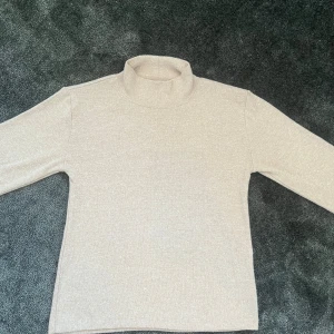 Beige stickad tröja från Zara - Säljer en snygg beige stickad tröja med en liten krage från Zara i mjukt stickat material. Färgtonen är ljusbeige och passformen är normal. Säljer den pga att den aldrig kommit till användning💕💕