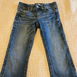 Ett par mörkblåa jeans från Gina Tricot - Jeansen är i storlek 158 och är lågmidjade. Mycket bra skick skulle jag säga. Skriv om du vill ha mer information