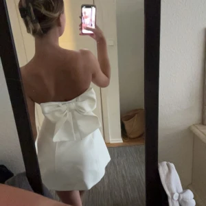 Vit klänning me rosett - Säljer denna as fina vita klänningen med en rosett på baksidan från zara. Den är använd en gång. Köpte för 400kr och säljer för 250kr (den finns inte kvar)