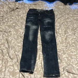Slim jeans från Dsquared2, mörkblå. Få en mystery gift på köpet😁 - Snygga slim fit jeans från Dsquared2 i mörkblå tvätt med slitningar och coola färgstänk. Klassisk femficksmodell med låg midja och raka ben. Tillverkade i Italien av högkvalitativ denim. Perfekta för dig som gillar streetstyle och vill sticka ut. Inget tecken på användning.