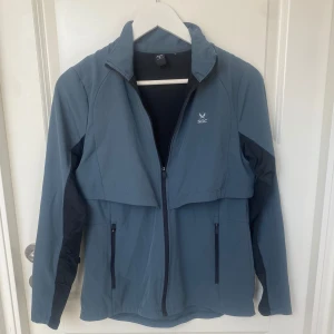 Bekväm träningsjacka  - Snygg blå träningsjacka från SOC med svarta detaljer på ärmarna. Jackan har hel dragkedja framtill, två fickor med dragkedja samt god ventilation! Kun provat på:)