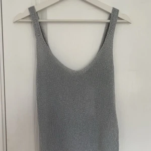 Silver glittrig linnetopp Gina Tricot XS - Supersnygg silverfärgad linnetopp från Gina Tricot i storlek XS. Aldrig använd och helt ny med prislapp.