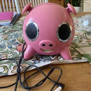 iPig Högtalare - En rosa Amethyst iPig högtalare! Relativt gammal men funkar hur bra som helst med förlängningssladd och adapter! (adaptern ingår inte). Fjärrkontroll som kräver nya batterier medföljer!