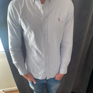 Randig Ralph Lauren skjorta - Snygg Ralph lauren skjorta. storlek S (slimfit) modellen är 182 och väger ca 71 kg. Skjortan är i fint skick och har används sparsamt.👑