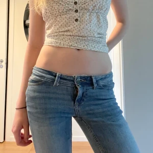 Lågmidjade bootcut jeans i ljusblå denim - Säljer ett par riktigt snygga lågmidjade jeans i ljusblå tvätt med bootcut-ben. Klassisk femficksmodell och cool faded effekt framtill. Midjemått tvärs över: 35 cm innerbenslängd: 80 cm🩷
