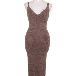 Klänning från adoore - Supersnygg brun stickad långklänning med ribbad struktur och smala axelband. Sitter super snyggt på.