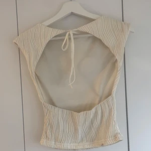 Vit topp med öppen rygg - Superfin topp med cool struktur och öppen rygg som knyts i nacken💕