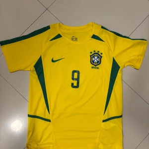 Fotbollströja VM2002 R9 - Skitsnygg oanvänd fotbollströja köpt i Brasilien, Rio, det är Ronaldo Nazario på ryggen och modellen är från VM 2002 när Brasilien vann VM. Tröjan är i storlek M och rekommenderad för personer som är runt 178, personen sista bilderna är 178cm. Om du har några frågor alls är det bara att skriva! 